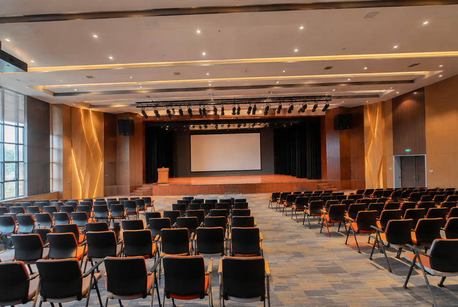 Wide view of a multipurpose auditorium space in India configured for a corporate presentation