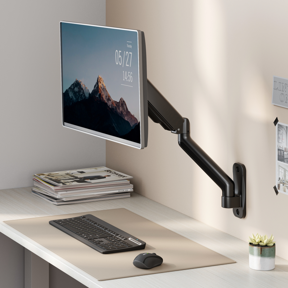 Lumi LDA32-112E mechanical spring monitor arm installed holding a monitor on a desk in an office setup