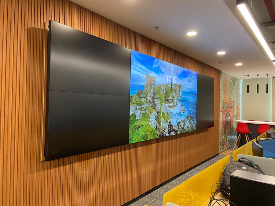 Six-panel LED video wall installed on a wood-paneled office wall in India, displaying high-resolution content beside modern workstations
